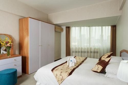 大连大连日航饭店公寓 的卧室设有一张白色大床和一扇窗户。