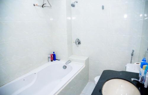 边和Ha Trinh Hotel的带浴缸、卫生间和盥洗盆的浴室