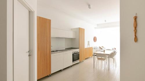 泰尔莫利Rivazzurra Homes - C的厨房配有白色橱柜和桌椅