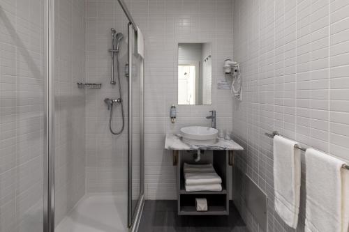 奥良Hotel Cidade de Olhão的白色的浴室设有水槽和淋浴。