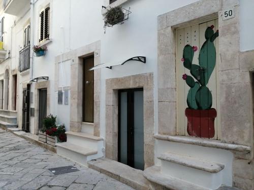 普蒂尼亚诺La Casetta di Isotta的仙人掌在街道上建筑物的一侧画的仙人掌