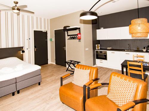 米德尔堡ApartHotel Waepen van Middelburg的客厅以及带床和椅子的厨房