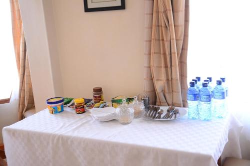 埃尔多雷特New Green Pastures Guest House的一张带瓶装水的白色桌子