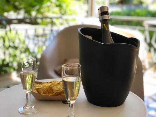 卡斯特罗卡罗泰尔梅Hotel Villa Serena的一张桌子上黑色容器里的一瓶香槟,带两杯