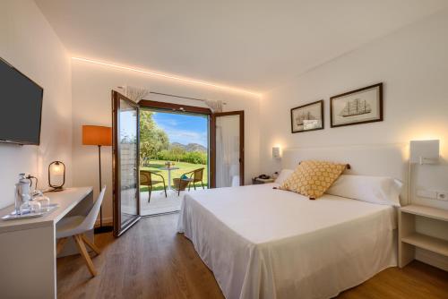 卡拉博纳圣科尔布精品酒店的一间卧室配有一张床、一张书桌和一个窗户。