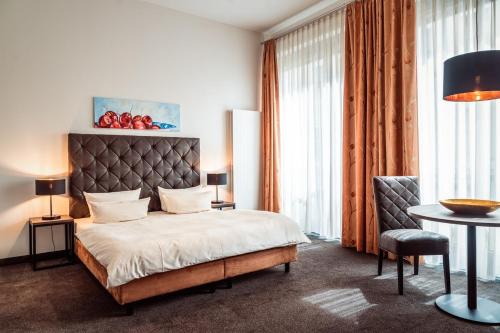德累斯顿诺伊马克特公寓酒店的卧室配有1张床、1张桌子和1把椅子