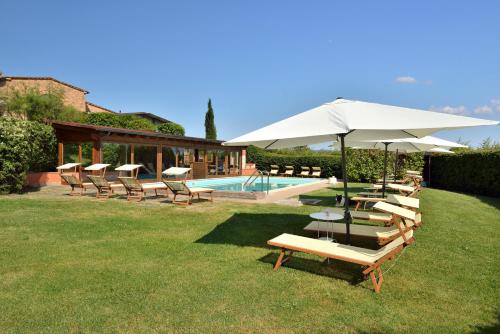 VillastradaPorsenna Resort的一组椅子和一把遮阳伞,位于游泳池旁