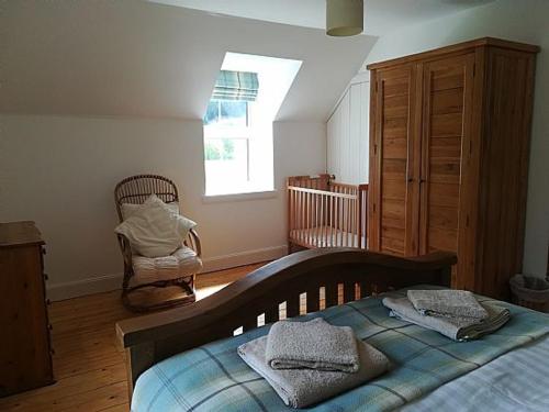 洛赫吉尔普黑德Keeper's Cottage的一间卧室配有一张床、一个梳妆台和一扇窗户。