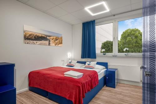 汉堡Koje Hostel的一间卧室配有一张带红色毯子的床和窗户。