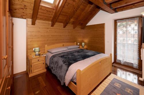 罗阿纳Larici Rooms的木制客房内的一间卧室,配有一张床