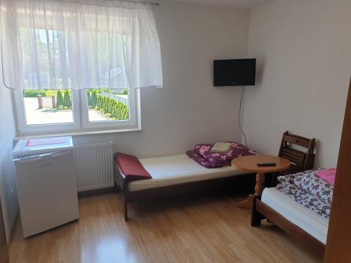 波莫瑞地区卡缅POKOJE U MIKOŁAJA的客房设有床、桌子和窗户。