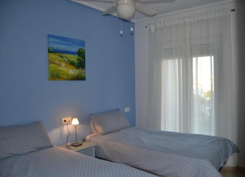 罗尔丹Casa Emperador - A Murcia Holiday Rentals Property的一间蓝色卧室,配有两张床和窗户