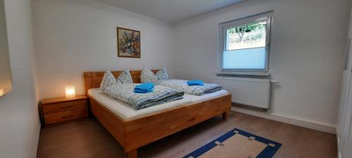 柯尼希施泰因易北Ferienhaus Gänseblümchen的一间卧室配有一张带蓝色枕头的床和一扇窗户。