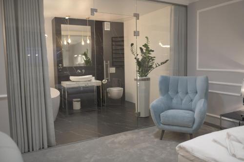 贝图夫Atmosfera Apartament 4的浴室设有蓝色椅子、水槽和镜子