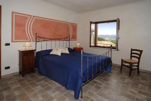 巴巴莱斯科Agriturismo Rio Sordo的一间卧室设有蓝色的床和窗户。
