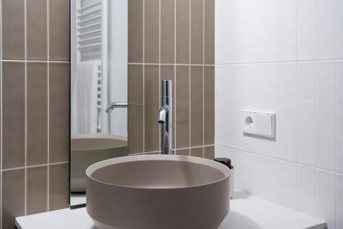 圣地亚哥－德孔波斯特拉SEIS ALDABAS Apartamentos的一间带大水槽和镜子的浴室