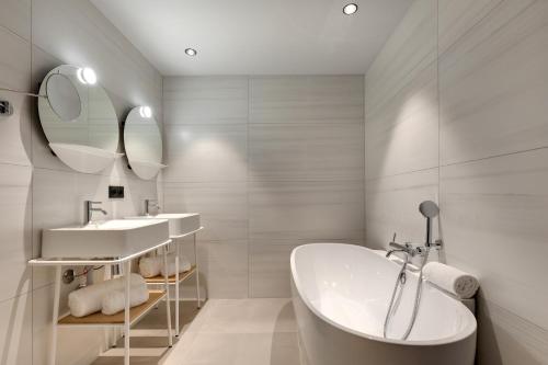 阿尔韦尔Château Fage La Maison des Vignes - Groupe Teritoria的白色的浴室设有浴缸和水槽。
