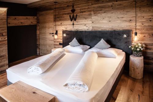 法尔泽斯温克勒康体公寓式酒店的一张白色大床,位于带木墙的房间