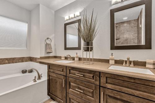 凤凰城Sunset Ridge的带浴缸、水槽、浴缸和镜子的浴室