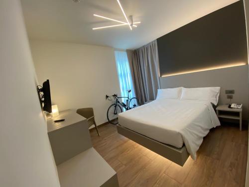 特伦托弗莱比克酒店的一间酒店客房,里面设有一张床和一辆自行车
