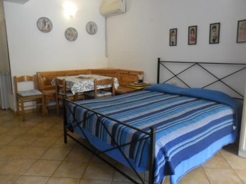 里奥马里纳Appartamenti Claudia Rio的卧室配有一张床和一张桌子及椅子