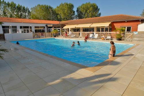 圣特罗让莱班Village Vacances Passion Les Bris的一群人在游泳池玩耍