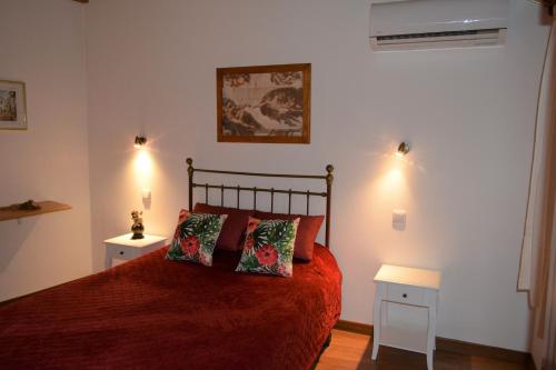 奎恩塔杜安乔Quinta do Tio Viagem的一间卧室配有红色的床和2个床头柜