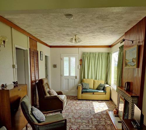 巴利博菲The Bungalow Self-catering Accommodation的客厅配有两把椅子和一张沙发