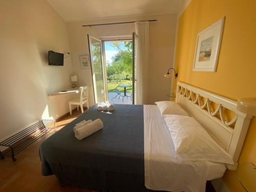 锡罗洛La Visciola - Country House del Conero的一间卧室配有一张床、一张书桌和一个窗户。