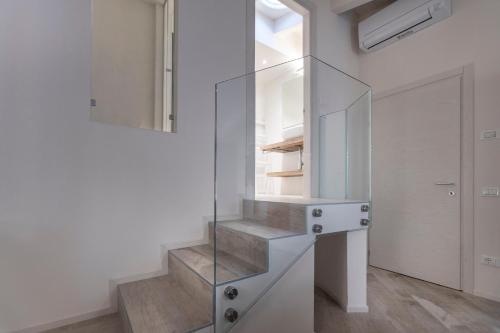 马尔切西内Picalof Apartments的白色房间,设有楼梯,设有玻璃楼梯