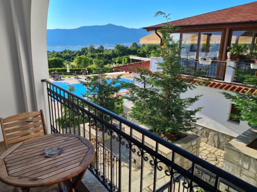 VelventósAgnanti Hotel的阳台配有桌子,享有游泳池的景色