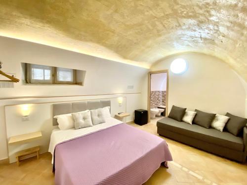 马泰拉Il Sorriso Dei Sassi Rooms的一间卧室配有一张床和一张沙发