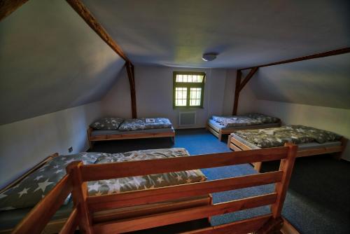 什捷季Pivovar Mlýn的带三张床和窗户的客房