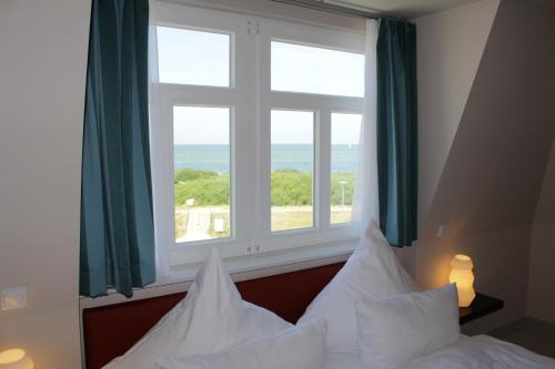 伯尔格伦德-雷特维施阿里尔海滩城堡旅馆的一间卧室设有一张床和一个大窗户