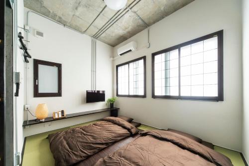 东京Oyado danran 団欒的一间卧室设有一张床和两个窗户。