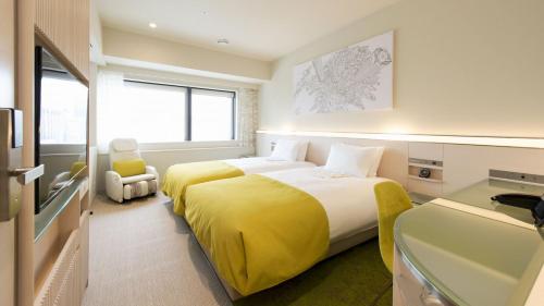 东京remm Roppongi的酒店客房,配有一张黄色毯子床