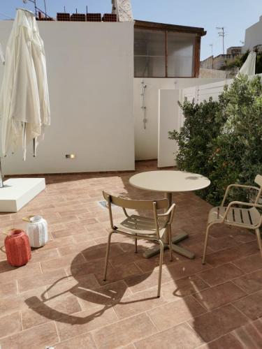 法维尼亚纳La Bottarga的庭院配有桌椅和桌子。