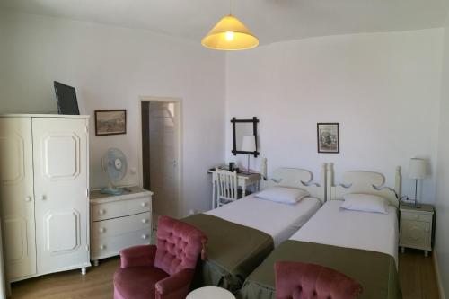 丰沙尔维拉特里辛那彭森酒店的一间卧室配有一张大床和两把椅子