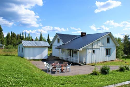 基律纳Camp Alta Kiruna的白色的房子前面设有桌椅