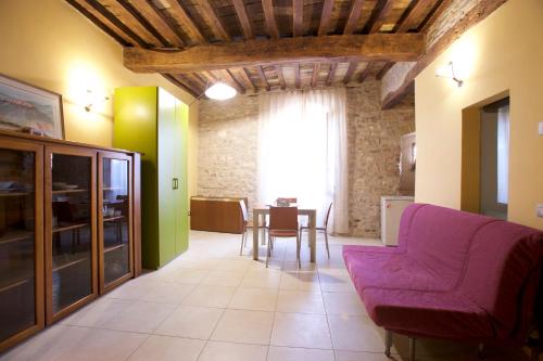 阿西西LE DIMORE ARCANGELO Maria的客厅配有紫色沙发和桌子