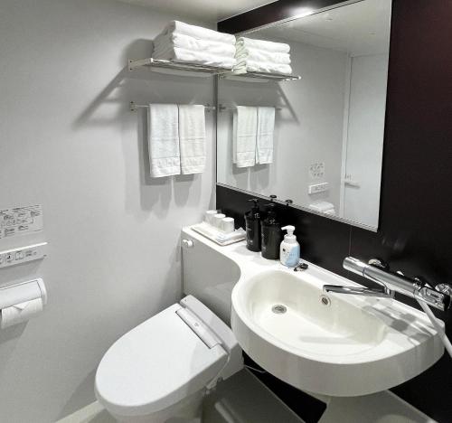 对马市対馬 central park hotel的浴室配有白色卫生间和盥洗盆。