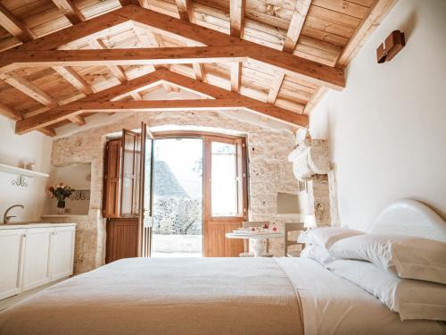 阿尔贝罗贝洛Rifugio di Puglia - Trulli & Dimore的一间卧室设有一张大床和一个窗户。