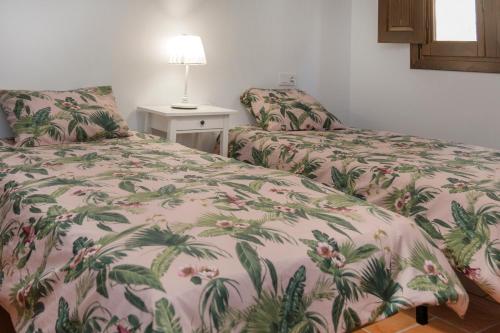 鲁比罗德莫拉CASA RURAL ADUANA的一间卧室配有两张床和一张带台灯的桌子