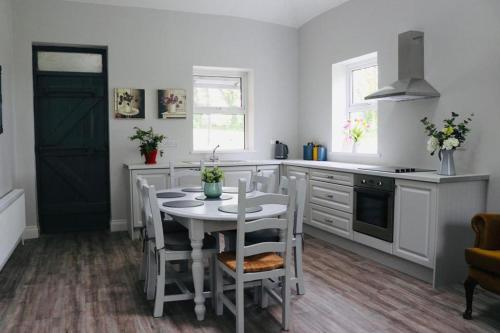 基拉尼WILLOW COUNTRY COTTAGE的白色的厨房配有桌椅