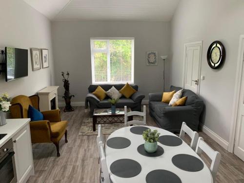 基拉尼WILLOW COUNTRY COTTAGE的客厅配有沙发和桌椅
