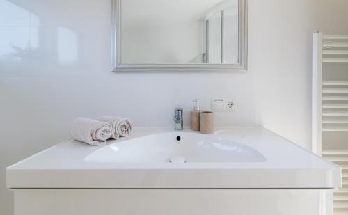 圣沃尔夫冈加尼布兴格尔酒店的白色的浴室设有白色水槽和镜子