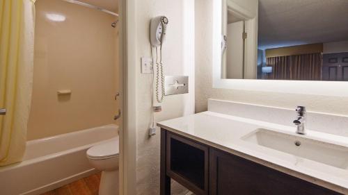 萨凡纳贝斯特韦斯特中央酒店的一间带水槽和卫生间的浴室以及一部电话