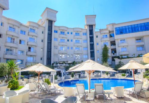 突尼斯突尼斯大酒店的一个带游泳池、椅子和遮阳伞的酒店