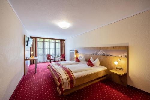 贝希特斯加登Hotel AlpinaRos的酒店客房,配有床铺和红地毯