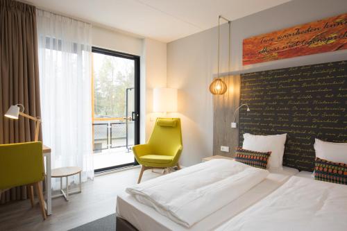 雷斯登兰歌德艾斯维酒店的酒店客房,配有床和黄色椅子